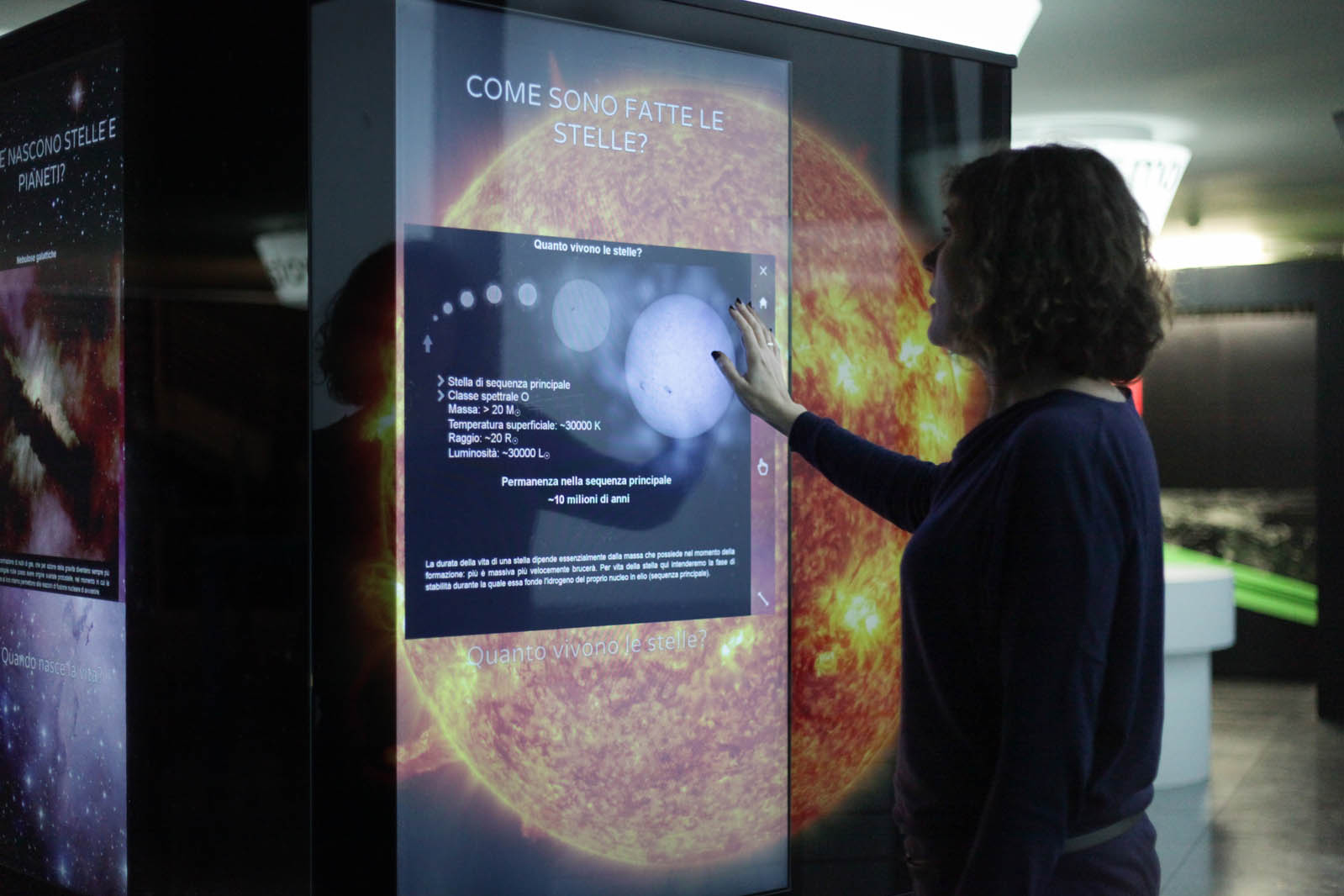 donna che interagisce con schermo multimediale rispondendo a delle domande sullo Spazio, nel percorso rinnovato da ett del planetario di torino