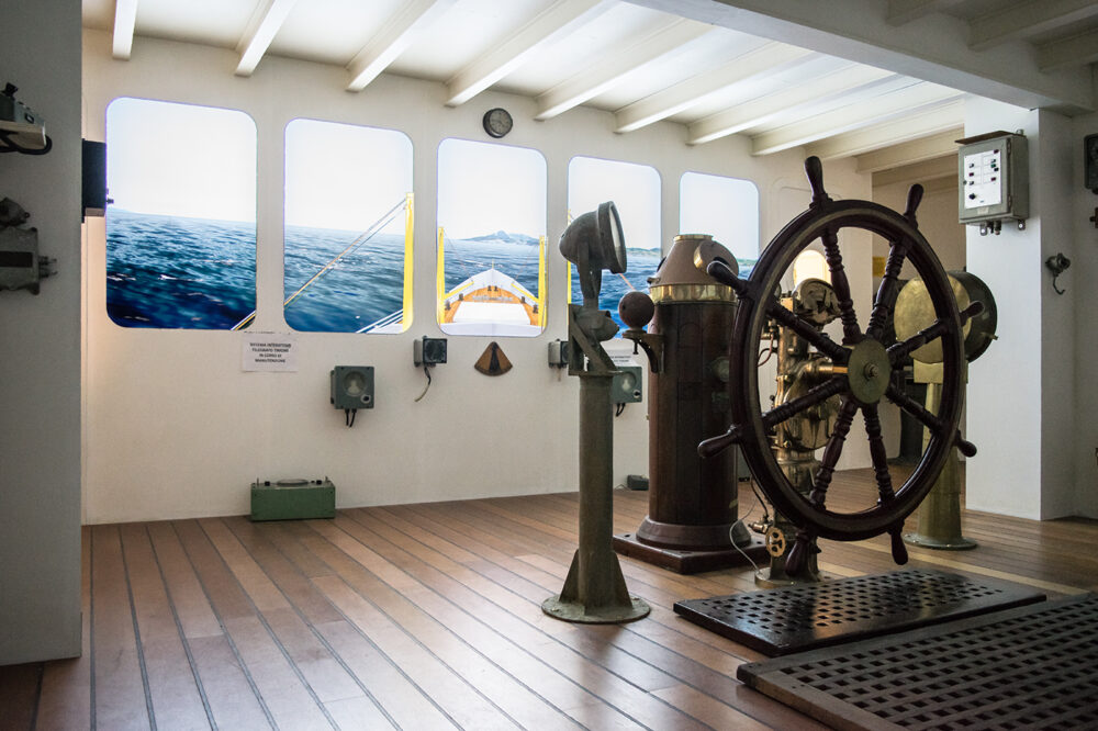 sala del museo navale di imperia in cui si simula la cabina di comando di un peschereccio attraverso dei monitor al posto degli oblo