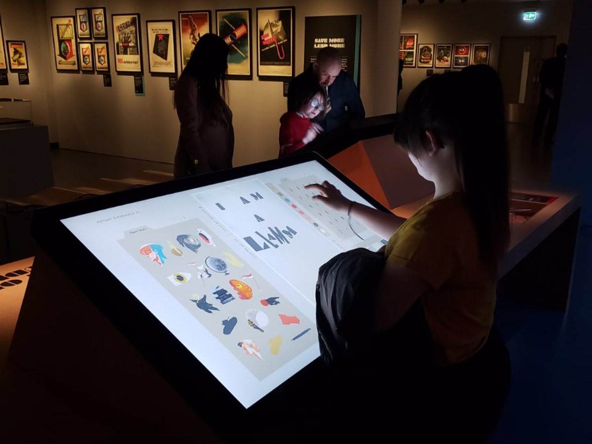 bambina che interagisce con display interattivo della mostra temporanea dedicata ad Abram Games al National Army Museum di Londra