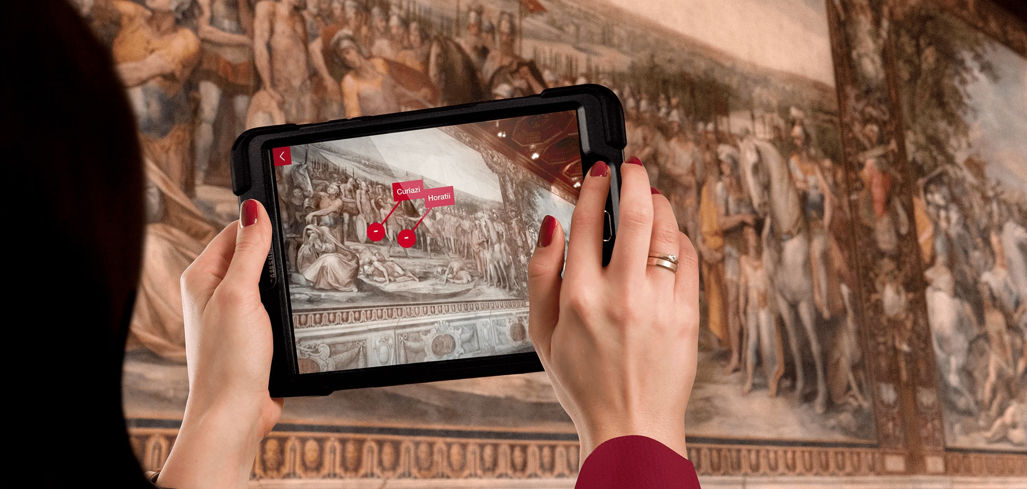 donna con tablet che utilizza la funzionalità di realtà aumentata durante la visita a musei in comune di roma