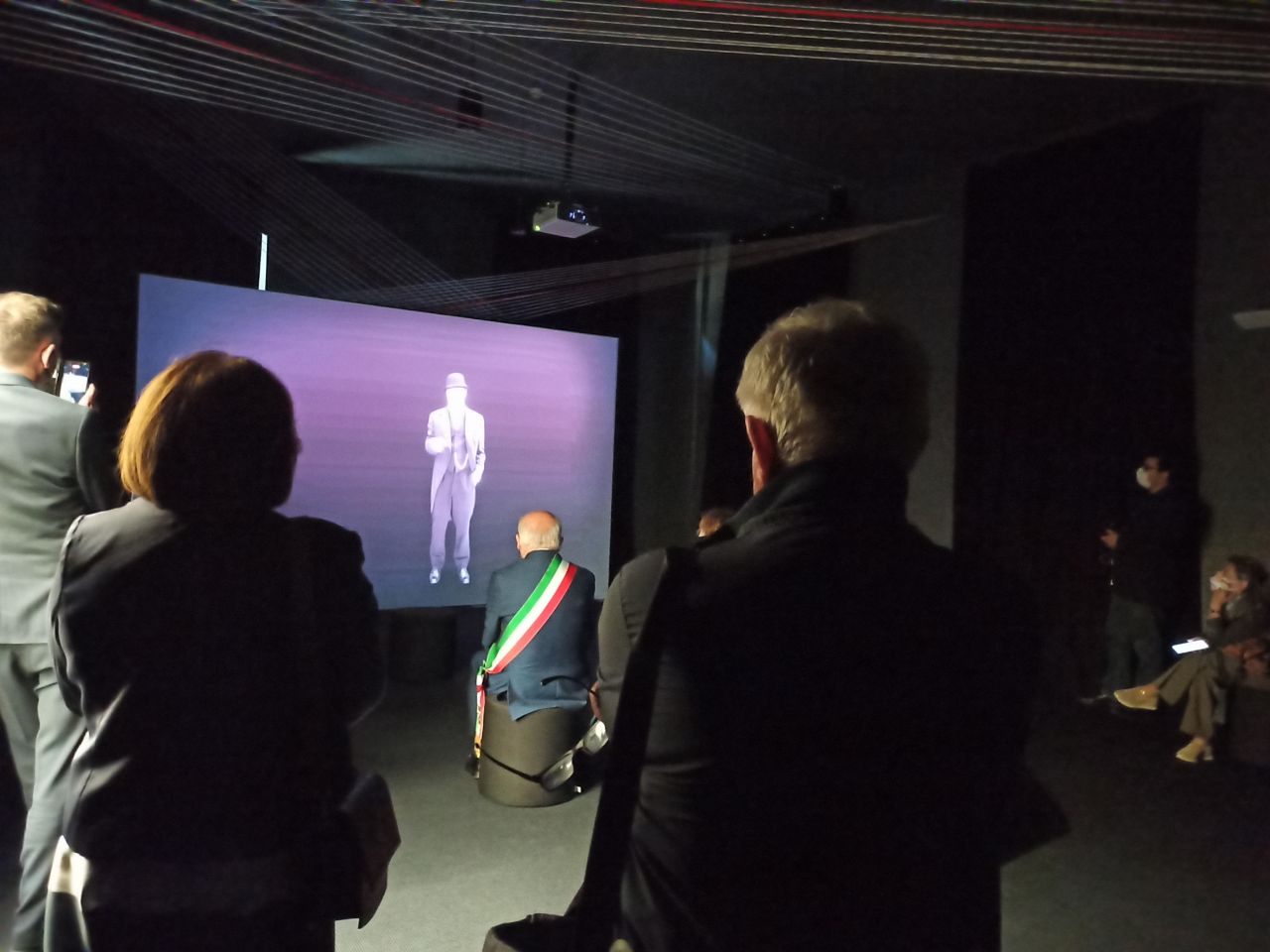 durante l'inaugurazione di Cresci d'Add, il sindaco e altri invitati guardano una proiezione su schermo