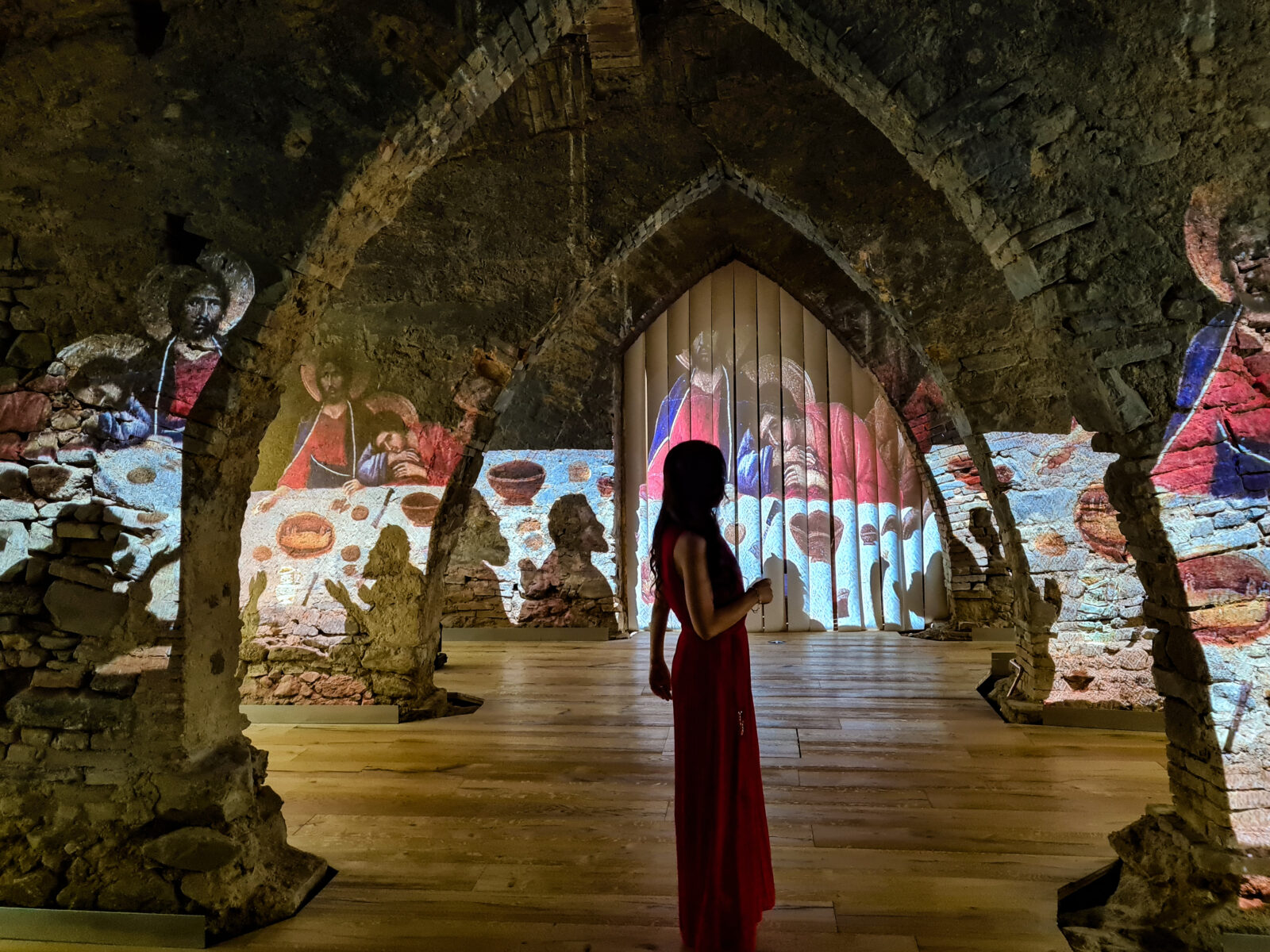 Ragazza in ombra nel Tempio del Brunello che osserva le proiezioni immersive di ett