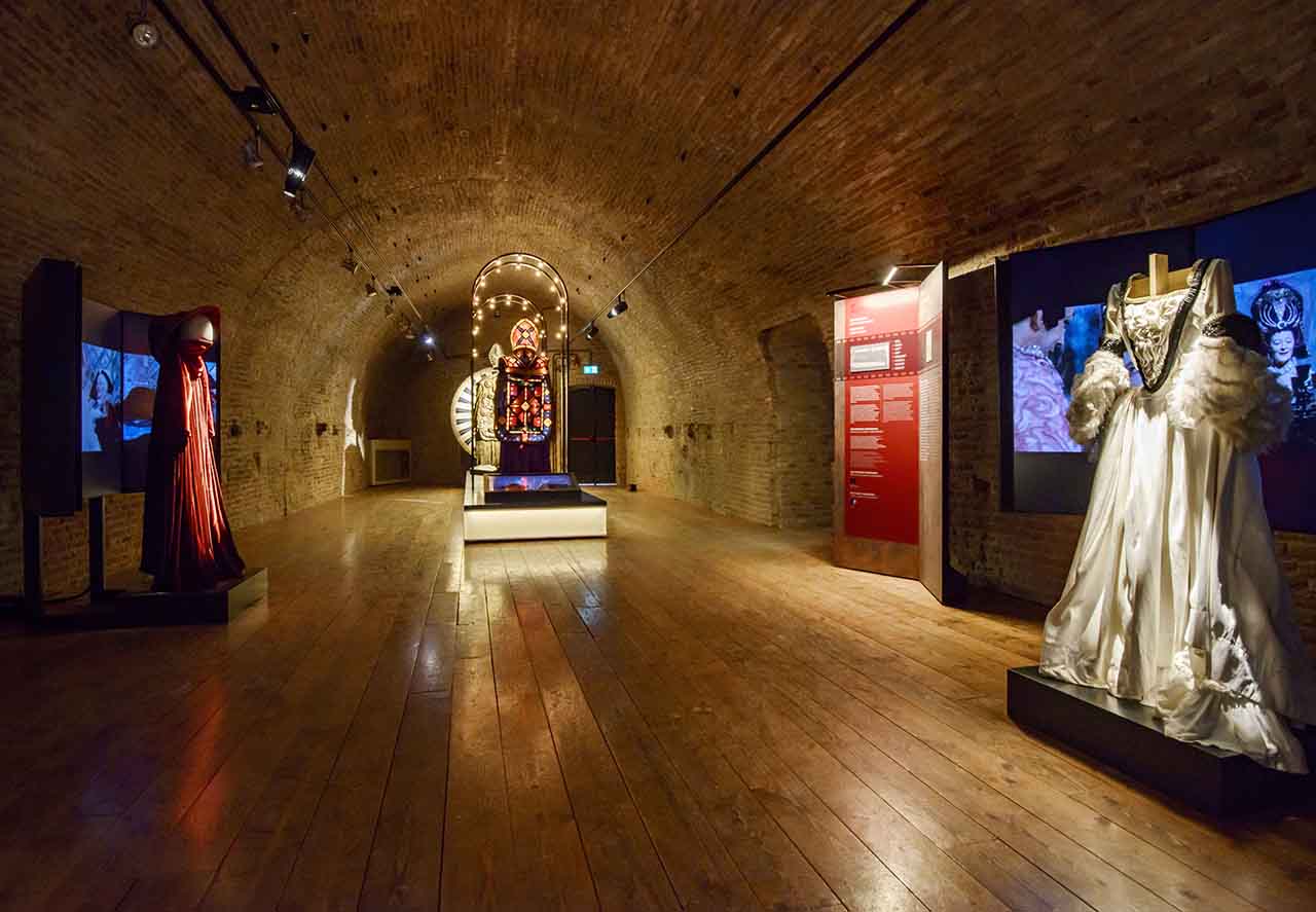 La sala dedicata ai costumi del Museo Fellini di rimini, con schermi che riproducono celebri scene di film, allestimento multimediale a cura di ett