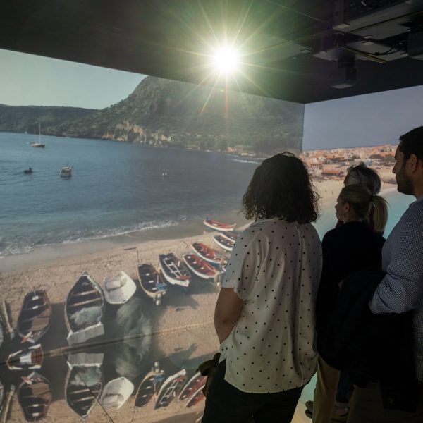 Visitatori all'interno della camera immersiva ad alicante realizzata da ETT per il Comune di Genova e che segue l'ocean Live Park in tutte le tappe di the ocean race 2022-23, sfondo con costa ligure e barche sulla spiaggia