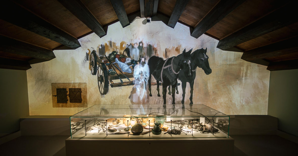 Illustrazione proiettata su una parete del Museo Archeologico Nazionale di Verona che ritrae il principe bambino defunto trainato da un carretto con due cavalli