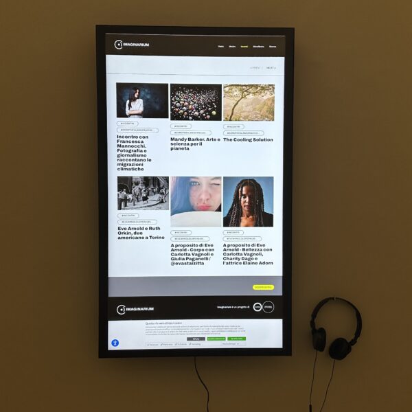 foto di un monitor interattivo, realizzato ed installato da ett, con delle cuffie all'interno di open camera