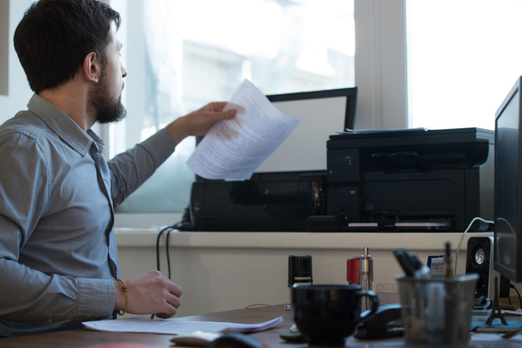 Ragazzo che scansiona e stampa certificati in ufficio