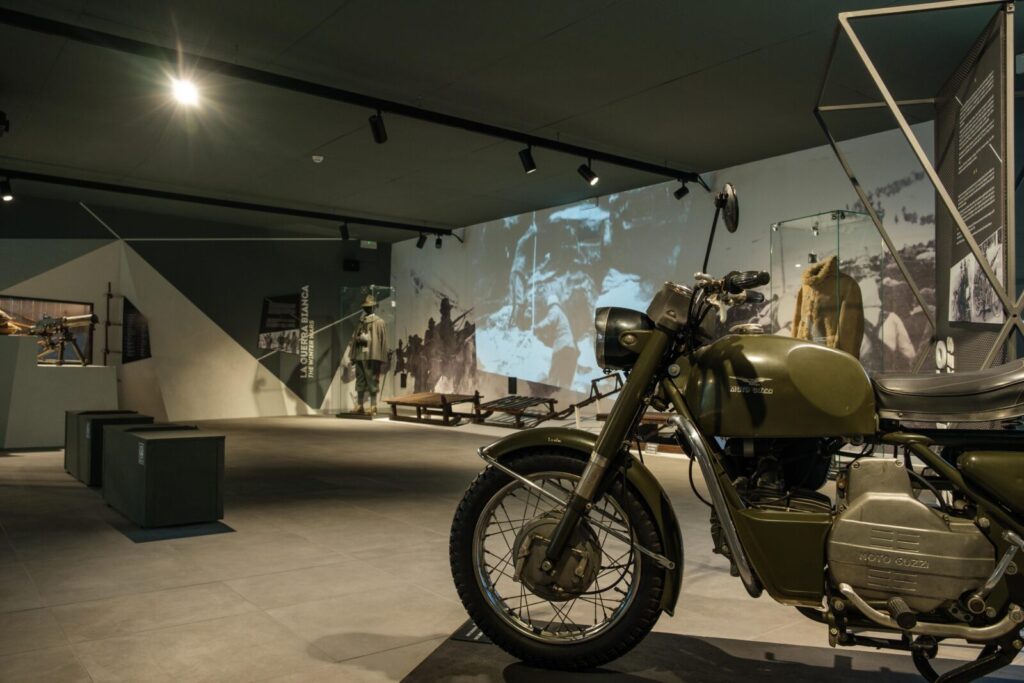 Moto in primo piano tra i reperti storici conservati al Museo Nazionale Storico degli Alpini a trento, trasformato in un'esperienza multimediale da ett