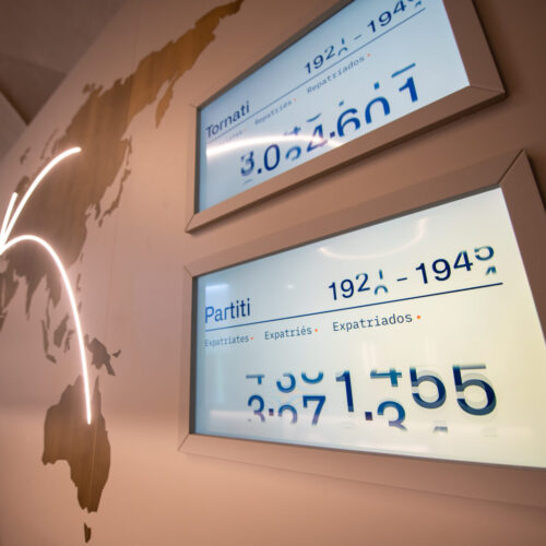 Schermi posti all'ingresso del Museo Nazionale Emigrazione Italiana con dati numerici su persone partite e ritornate