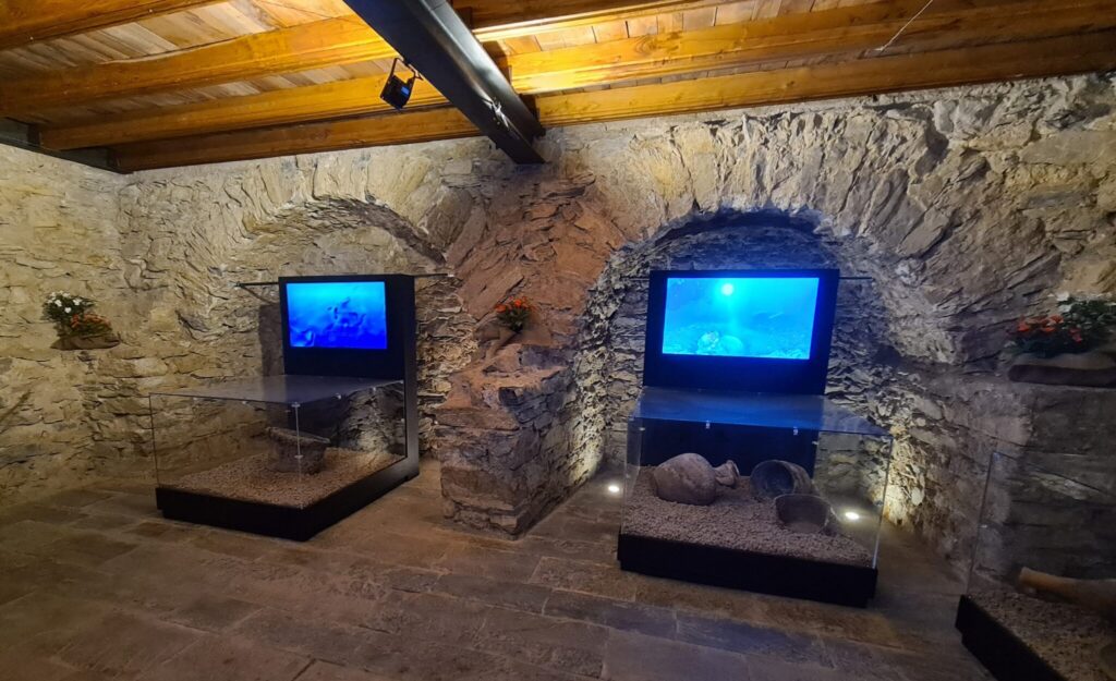 Gli allestimenti multimediali di ETT presso il castello cinquecentesco di Santa Margherita Ligure, due teche con anfore e sopra due schermi multimediali