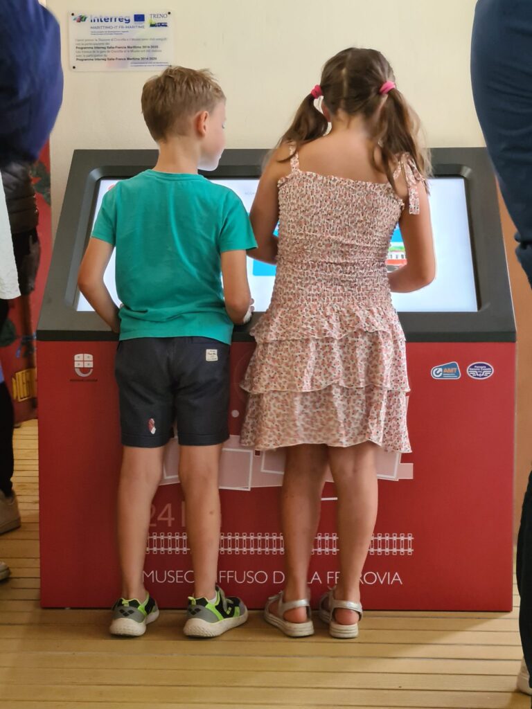bambini che giocano con una delle 3 postazioni touch realizzate da ett per l’Archivio Ferrovia di Genova a Casella