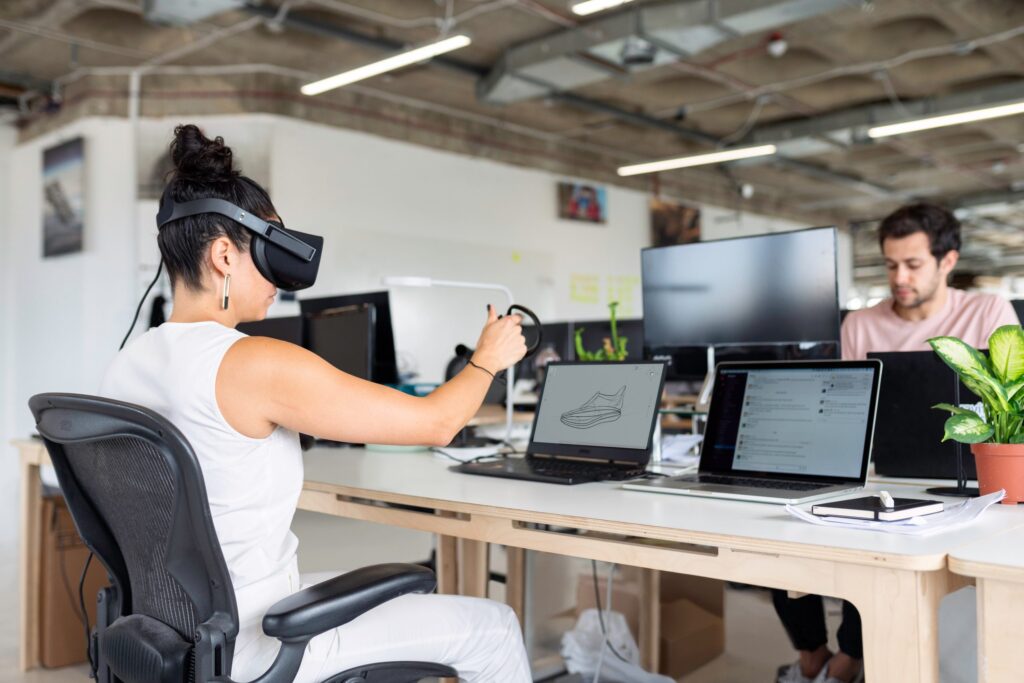 donna che utilizza visore e controller per la VR in ufficio