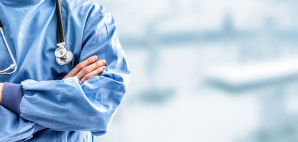 busto di un medico con camice blu a braccia incrociate davanti al petto, con al collo il fonendoscopio