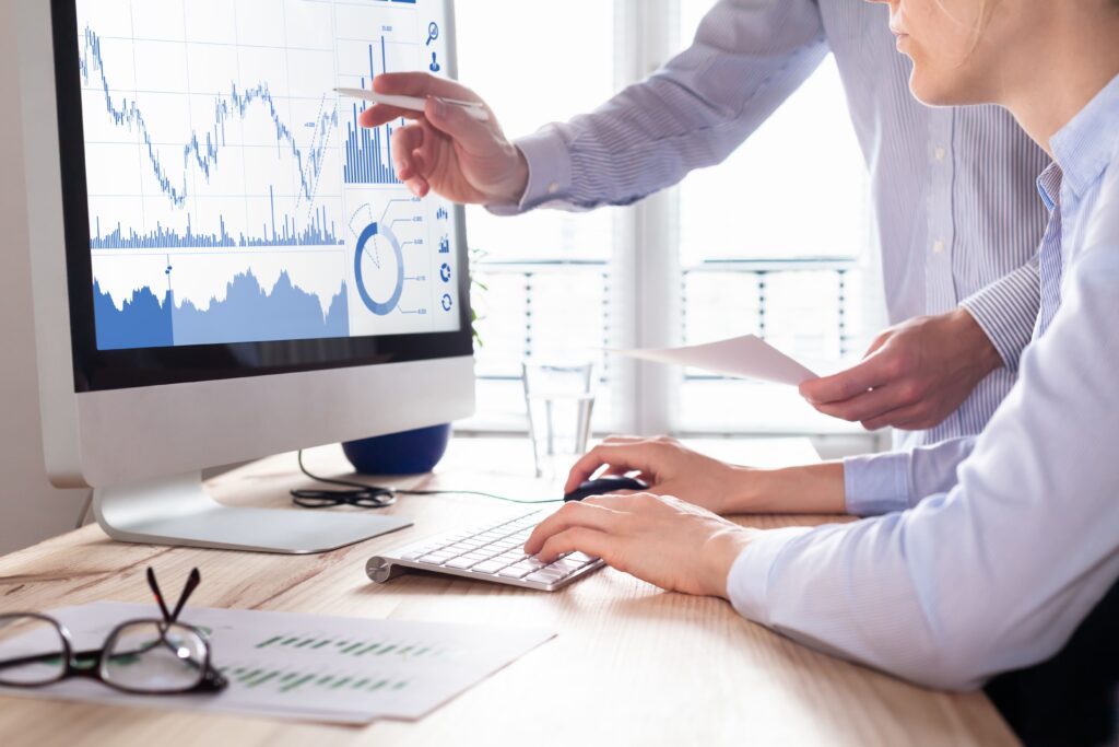due persone in ufficio davanti allo schermo di un computer mentre visualizzano un insieme di grafici