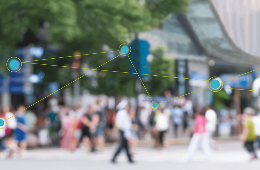 foto sfocata di una folla di gente in un paesaggio urbano con davanti un'infografica composta da pallini azzurri collegati tra solo da linee verdi