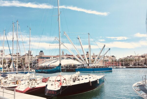 foto del porto antico di genova con barche a vela in mano e sullo sfondo il bigo