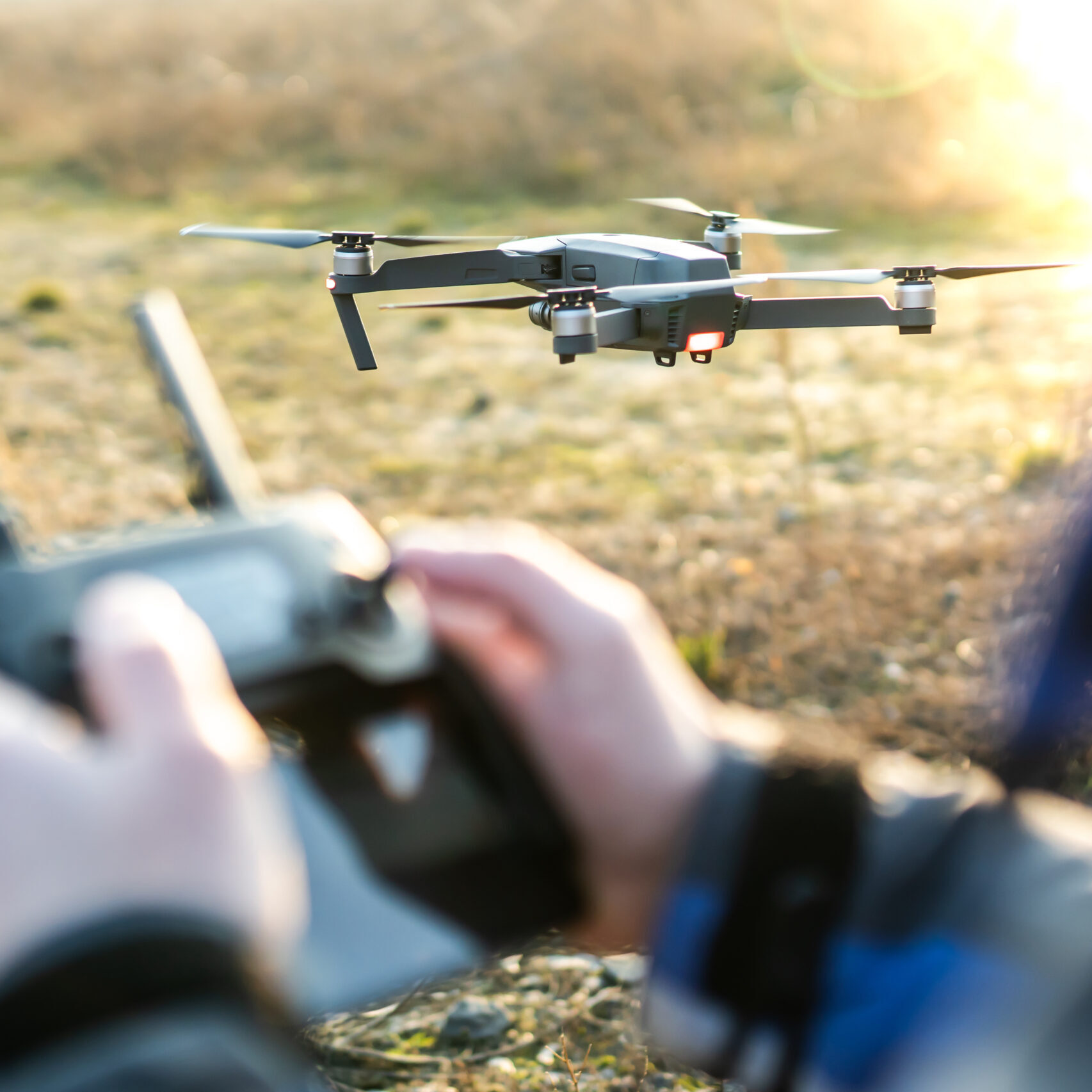 uomo che telecomanda un drone in un campo