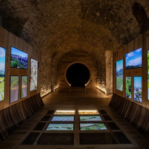 interno del tempio del brunello, corridoio con monitor sul pavimento e lungo le pareti