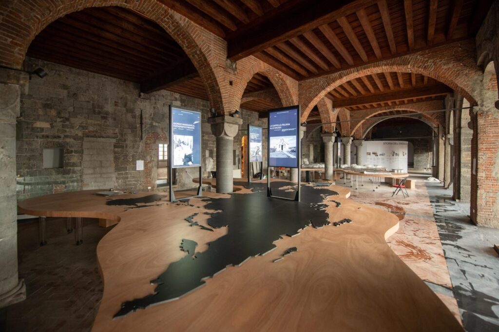 allestimento del primo piano del museo dell'emigrazione italiana, dove si vedono i tavoli con il planisfero e i monitor interattivi di ett