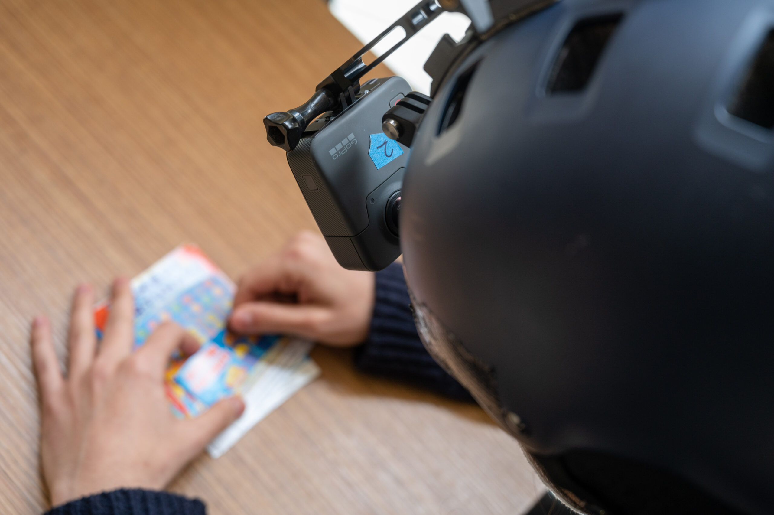 Mani di donna che gratta un gratta e vinci inquadrata da una cam 360 per la realtà virtuale