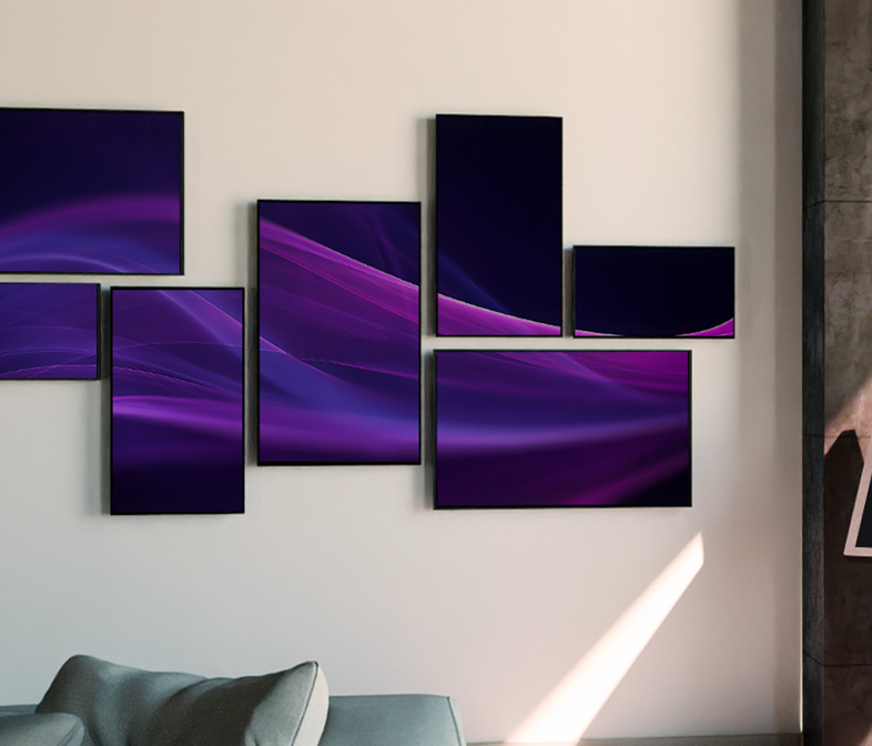 digital signage, composizione di monitor di varie dimensioni installati su una parete chiara