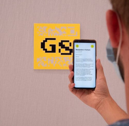 ragazzo con in mano un cellulare che inquadrano il qr code per scaricare l'applicazione fare luce: i fatti del g8 in un'app realizzata da ett