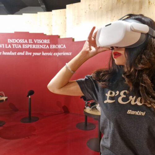 in primo piano sulla destra una ragazza mentre utilizza il visore vr nella stanza di casa eroica nella postazione rossa con postazioni vr con visori