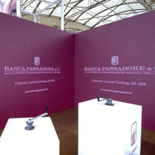 stand della banca passadore durante l'evento dell'ocean rce a genova, pannelli su sfondo vinaccio