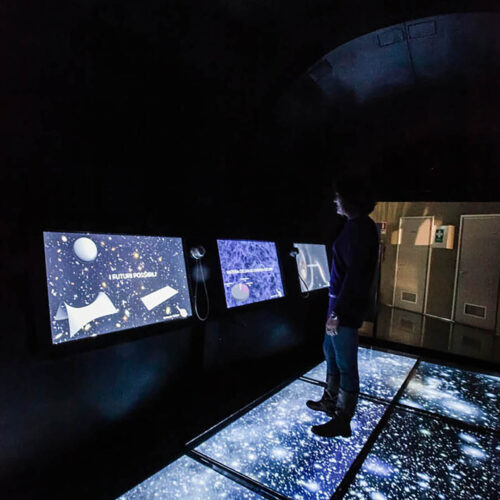 persona davanti exhibit multimediali che rappresentano Astronomia e Spazio, nel percorso rinnovato da ett del planetario di torino