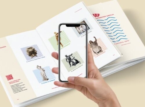 mano che scansiona tramite fotocamera di un cellulare il catalogo del museo utilizzando l'applicazione relizzata da ett