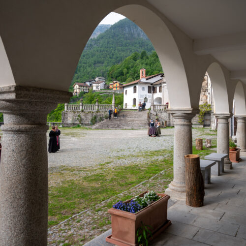 attori in costume sullo sfondo, porticato in primo piano, produzione VR ETT Storie di Pietra, la vita nell'altra Valle del Cervo