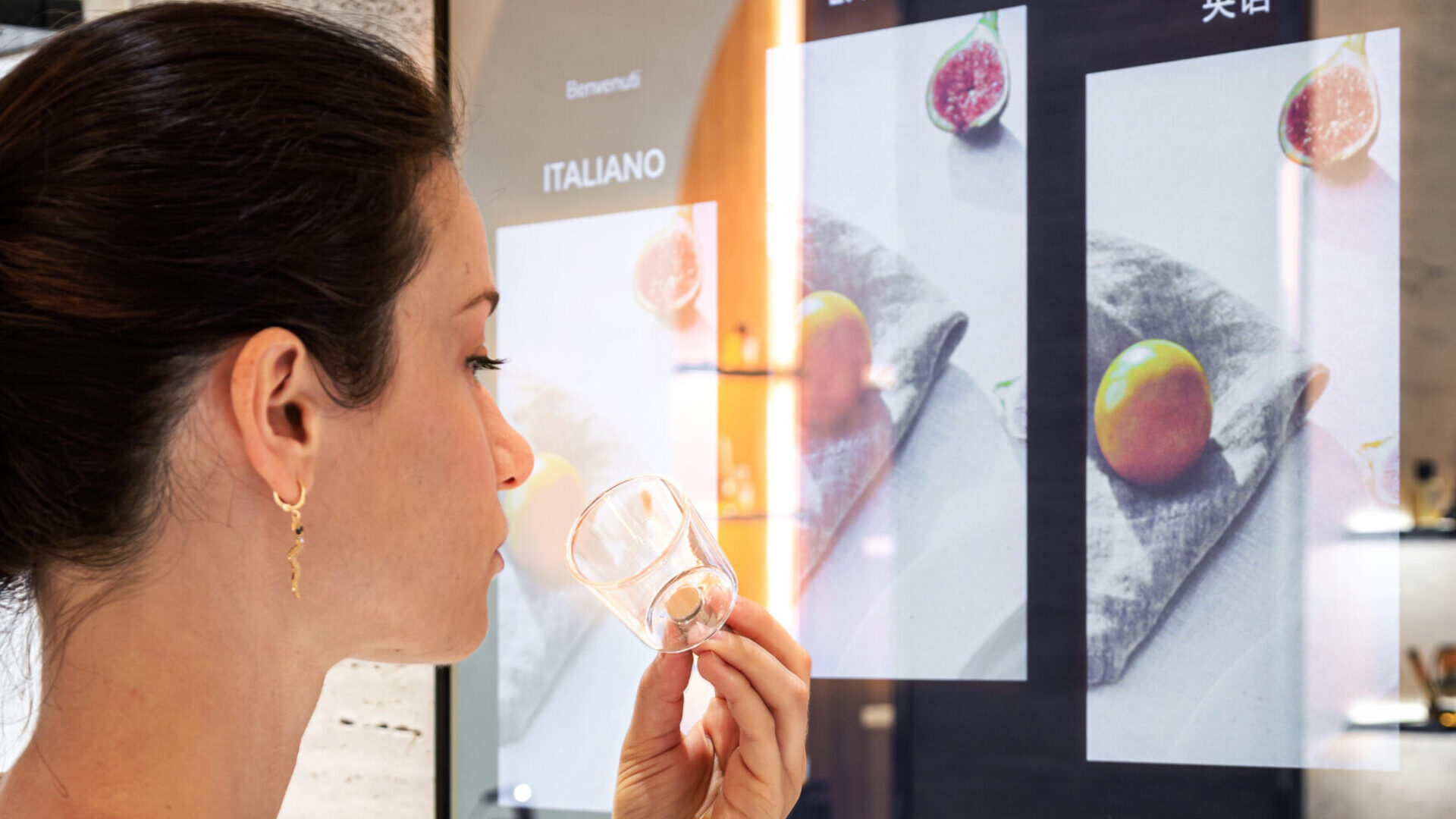 donna che odora una campana olfattiva, parte dell'allestimento del fragrance finder realizzato da ETT per acqua di parma