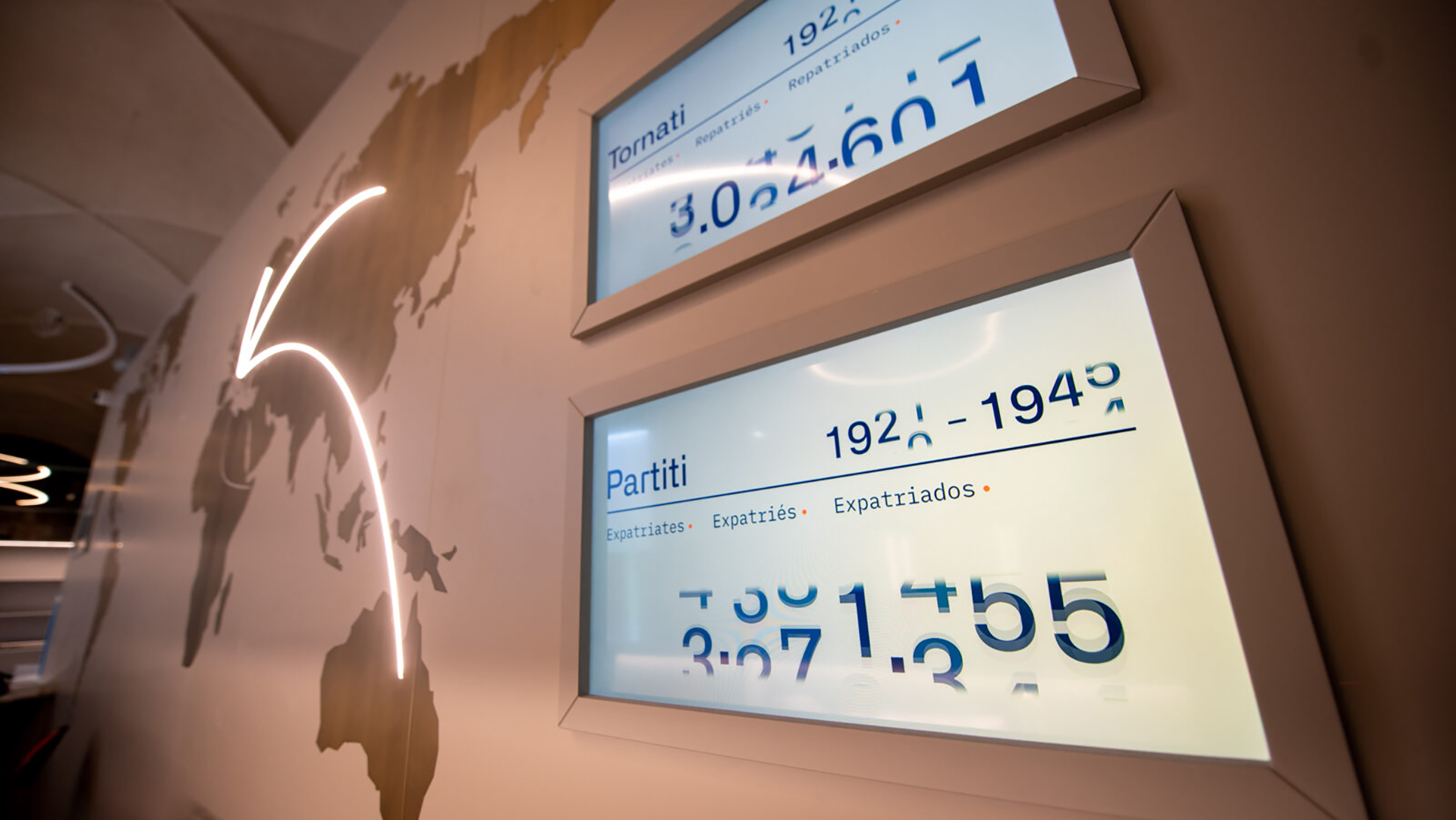 Schermi posti all'ingresso del Museo Nazionale Emigrazione Italiana con dati numerici su persone partite e ritornate